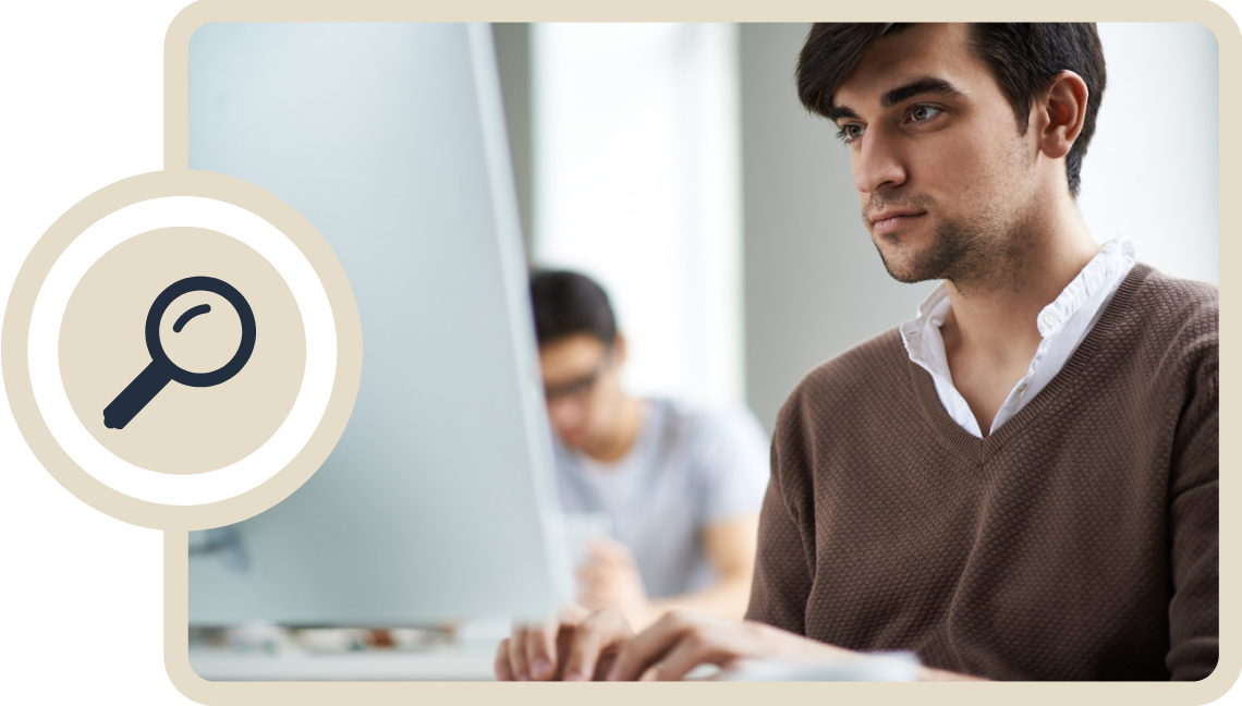 guy on computer with co worker in background 2